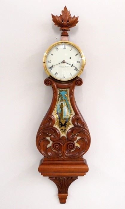 A 1971 Elmer O. Stennes Lyre Banjo clock. 8-day weight driven time only movement marked "E O Stennes, Weymouth, Mass. 70" painted metal dial with Roman numerals marked "Elmer O. Stennes, Weymouth, Mass", cast iron weight with Stennes mark. Mahogany case with carved lyre throat and reverse painted glass, marked "14" for the 14th clock made after Stennes was imprisoned, "71" for 1971 and "M. C. I. P." for Massachusetts Correctional Institute, Plymouth, with additional Stennes brand on backboard. This clock is in very good condition without repair and was running when cataloged. 42 1/2" high overall. ESTIMATE $2,000-3,000