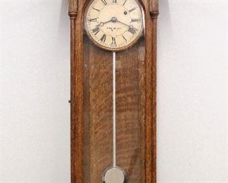 A late 19th century E. Howard & Co. Model 59-6 "Vienna" style wall clock. 8-day weight driven time only movement marked "E. Howard & Co. Boston, 70" with painted metal dial and Roman numerals marked "E. Howard & Co. Boston", round wooden pendulum rod with silver paint and damascened bob. Oak case with shaped top and three turned finials over a single long door and shaped lower drop with three turned and carved drop finials. Older refinishing with minor wear, several small paint touch ups on dial, running when cataloged. 37 1/2" high overall. ESTIMATE $2,000-3,000