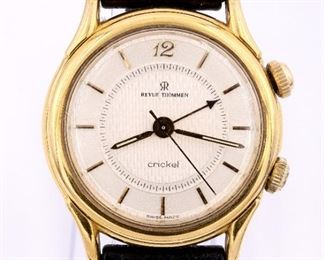 A vintage 18k Revue Thommen "Cricket" wristwatch. Manual windmovement with "Cricket" alarm, round Champagne dial with Gold baton markers, in a 35 mm 18k Gold case with replaced IWC leather strap and 18k buckle. 50.5 grams total weight. Case unopened, some wear, scratch on rear cover, running when cataloged. ESTIMATE $600-800
