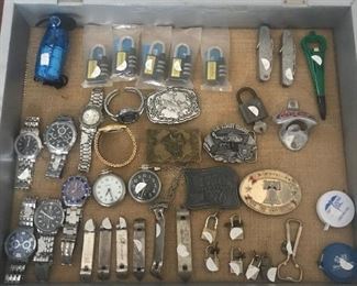 Showcase with US military pocket knives, vintage Coca-Cola bottle opener, men’s and women’s watches, combination locks and key locks, can openers and belt buckles.