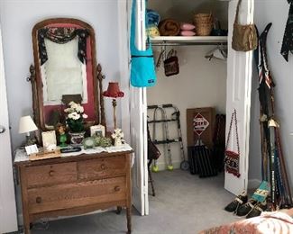 Vintage oak dresser, vintage snow skis, walker. In the closet are wood TV trays