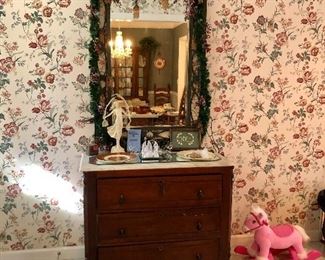 Walnut, marble top 3 drawer chest, a green mirror with Christmas lights and a pink pony.