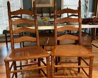 2 of 10 ladder back chairs, oak with cane seats.