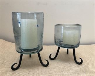 Pair of blown glass hurricane candle holders with metal tripod frames