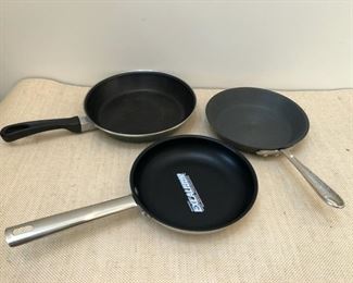 From left to right: Green 10" open fry pan, new Wolfgang Puck Bistro Collection 8" nonstick, stainless steel omelette pan, Meyer Professional Hard Anodized 8" omelette pan
