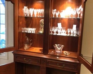 Stickley china cabinet with interior lighting measures 53" W x 88" H x 19" D. Waterford Lismore crystal, Vannes glass bowl, Bulova clock in cloche, vintage Fostoria etched crystal wine glasses