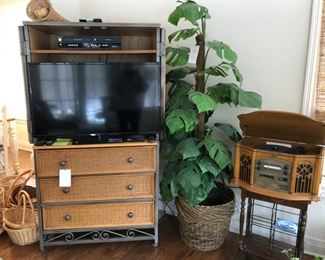 Wicker media cabinet, flat screen TV, baskets, faux palm tree and record/CD player