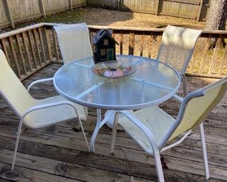 Glass top aluminum table with 4 mesh chairs.