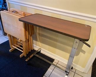 Set of tray tables on stand and adjustable portable table.