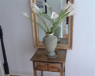 Small two drawer table; vase with peace lilies; mirror