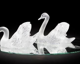 2002
A Pair Of Lalique Art Glass Swans
Fourth-quarter 20th Century
Each with acid etched signature: Lalique (R) France
The pair of frosted and clear glass swans one with head raised, one with head lowered set on a mirrored oval plateau with etched waves, 3 pieces
Overall: 9.75" H x 33" W x 22" D
Estimate: $1,000 - $1,500