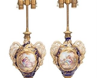 2124
A Pair Of French Sèvres-Style Table Lamps
First-quarter 20th Century
Each a baluster-form with opposed rams heads and foliate relief decorations on a cobalt ground with gold enamel highlights and two roundels depicting a pastoral courting scene on one side and a landscape on the other, issuing a gilt bronze column terminating in two light sockets with pull chains and topped with a pointed finial, raised on a fluted base with gold enamel details above a square support, 2 pieces
29.25" H x 9" W x 6.5" D
Estimate: $500 - $700