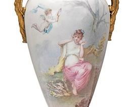 2125
A Sèvres Urn With Portrait Scene
Fourth-quarter 18th Century
Marked to base for Sèvres
The gilt bronze-mounted baluster-form vessel with opposed winged figural busts and depicting a Neoclassical portrait scene, with a fluted neck on a tapered body and raised on a fluted base with gilt-bronze details and gold enameling on a green and white ground, above a bronze footed support with foliate motifs, topped with a gilt-bronze acorn finial to lid
21" H x 7.75" W x 6" D
Estimate: $500 - $700