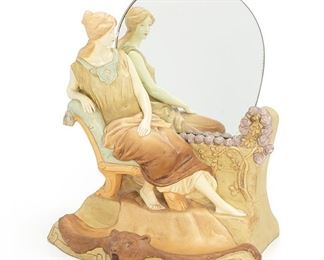 2204
A Figural Royal Dux Vanity Mirror
Circa 1920s
Marked for Royal Dux and numbered: 10-75 / D-59
Designed with a reclining Grecian woman over a bear skin rug tray
16.25" H x 13.25" W x 10.5" D
Estimate: $300 - $500