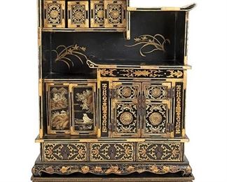 2238
A Japanese Decorative Table Top Cabinet
Late 19th/early 20th Century
The black lacquered and gilt cabinet with tiered top over an asymmetrical fitted interior containing pigeonholes, sliding door compartments, a two-door compartment, and three drawers with metal hardware and decorated with figural landscape scenes and gilt floral and ornamental motifs atop a footed base
26.75" H x 19.75" W x 9.25" D
Estimate: $500 - $700