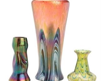 2245
Three Loetz Iridescent Glass Vases
Late 19th/early 20th Century; Bohemia (Czech Republic)
Comprising three Art Nouveau glass vases in varying forms, one tall pink and blue iridescent vase, one narrow molded vase in purple and green glass, and one small green bud vase with bulbous base, 3 pieces
Tallest: 12.125" H x 5.5" Dia.
Estimate: $400 - $600