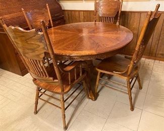 Oak Wood Table and 4 Matching Chairs. 2 chairs have arms and 2 do not. Table also includes 2 foot leaf. 
