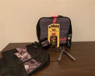 Two Ameristep pouches, 1 game caller, 1 Austin Trading Co thermal bag, 1 bottle of doe urine, and 1 leather man tool in holder.