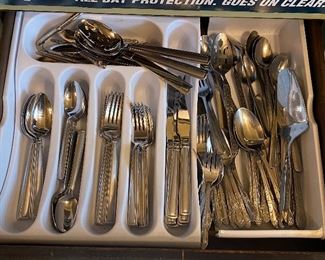 Drawer Full of Flatware. Includes at least 7 matching large forks, small forks, large spoons, 16 small spoons, 8 butter knives that all match. Assorted other flatware in drawer as well.