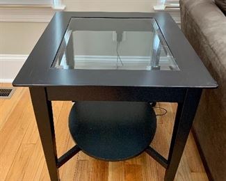 $200 - Pair of black painted wood with beveled glass insert end table with oval bottom shelf.  24.5"H x 24"W x 28"D.  As is.  One of two.