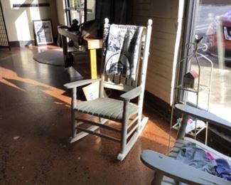 One of two white porch rockers with metal stand.