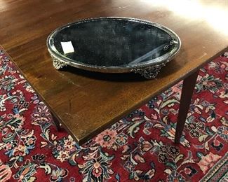 Oval beveled edge reflector on large drop leaf dining table with three leaves.
