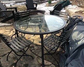 patio table with four folding metal chairs and umbrella and strong cover for all of it