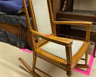 wooden rocker with cream/grey cushion. intricate carvnings