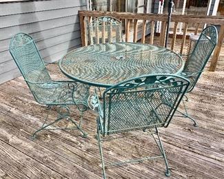 $250 - Five piece green metal outdoor patio set. Table: 29"H x 48"D. Chair:  38"H x 26.5"W x 22.5"D (seat height 16.5"H)
