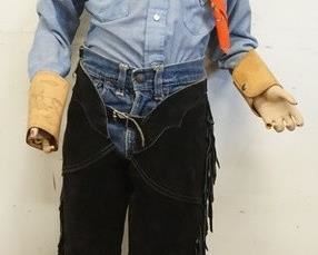 1049	YOUNG BOY MANNEQUIN CLOTHED IN VINTAGE LEVIS SELVEDGE JEANS W/ BIG E, CHAPS W/ ZIPPER & FRINGE, ARM CUFFS DECORATED W/ HORSES, ELY SHIRT & A BANDANNA. MANNEQUIN IS MISSING FINGERS ON BOTH HANDS & MAY SUFFER ADDITTIONAL LOSSES TO BODY/FACE. APP. 47 IN TALL

