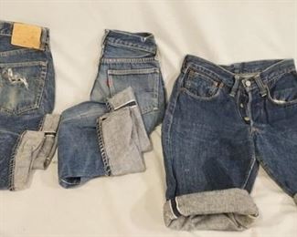 1138	LOT OF THREE PAIRS OF VINTAGE LEVIS SELVEDGE JEANS. ONE PAIR HAS BEEN CUT INTO SHORTS WAIST MEASURES APP. 27 IN. ONE PAIR IS MARKED SIZE 27 X 30 THE LAST PAIR THE WAIST MEASURES APP. 24 IN REVERSE OF TOP BUTTON IS STAMPED E. VARYING DEGREES OF WEAR 
