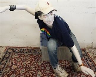1141	SEATED BOY MANNEQUIN CLOTHED IN LEVIS JEANS, SNEAKERS, T-SHIRT, WRIST BAND, SWATCH WRIST WATCH & LEVIS BASEBALL CAP. APP. 46 IN TALL. MANNEQUIN MAY SUFFER LOSSES TO BODY/FACE

