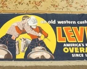 1192	VINTAGE LEVIS ADVERTISING BANNER WHICH READS *AN OLD WESTERN CUSTOM… LEVI'S AMERICAS FINEST OVERALL SINCE 1850*  IT IS 110 IN X 29 IN 
