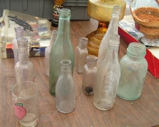 bottles with writing on them plus amber colored oil lamp