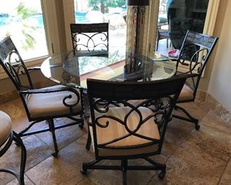 $675- Amazing round glass top table iron base table with four rolling chairs 