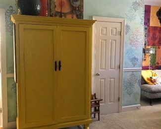 great yellow armoire with fabulous painted piece on top and 2 fabulous oversized glass vases and an aluminum one with a patinated finish