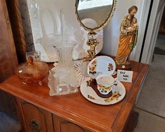 Sweet golden dresser mirror with cherub, vintage chalkware Joseph with Jesus, antique glassware,  huge porcelain seving platter, vintage walnut side table