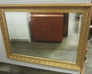 LARGE WALL MIRROR WITH BEVELED GLASS IN GOLD FRAME. 42 X 30"