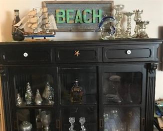 The black display case has been sold but all the decorative pieces are still available.  Model ship with awesome details!  Lots of mercury glass, metal beach sign lights up!!