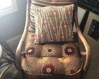 Nice wicker chair with beautiful textured pillows.