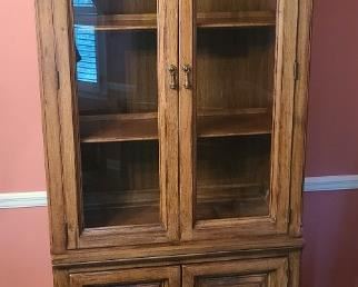 https://ctbids.com/#!/description/share/719398 Wooden glass front china cabinet. Shelving has lights behind it to show off your displays. Bottom cabinet has two shelves underneath. Measures 36" x 18" x 83"

