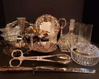 https://ctbids.com/#!/description/share/719465 Silver Plated And Crystal Tableware. Includes tongs, spoons, knife, napkin holder, trays, candle holders, oil and vinegar set, glasses and plates. Largest measures 10"L x 6"H and smallest measures 3"H x 4"L.


