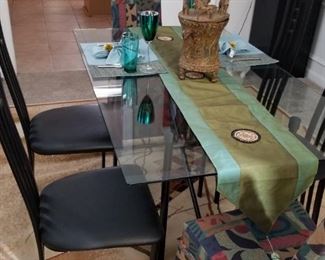 Glass top black base with 4 chairs. The 2  printed captain chairs they are available