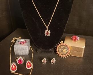 https://ctbids.com/#!/description/share/721061 Collection of red gemstone jewelry. Two rings are sterling silver and approximately size 7. Pear-shaped ring is closer to size 8. Authenticity of other metals and gemstones unknown.