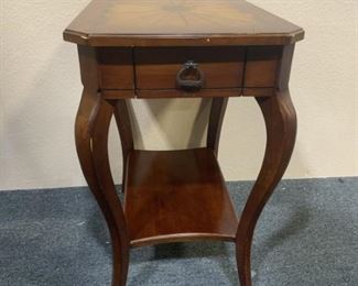 Butler wood side table with gold design.