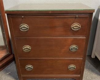 Bachelor chest with three drawers. Wood chipped off one corner, has glass top.