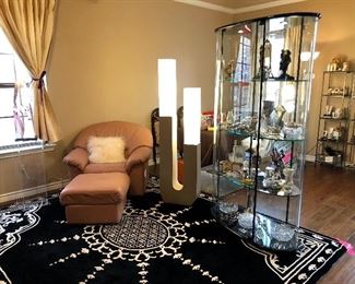 Natuzzi pink/blush leather modern armchair and ottoman.  Cantoni 360 degree oval glass and black lighted cabinet.  Statement piece!  Fantastic rug!!  Notice the Haziza sculpture to the left of the chair.