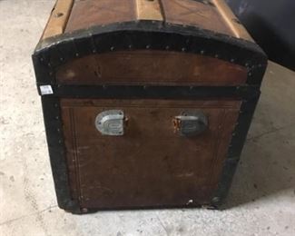 Leather covered trunk. The leather covering on this trunk is in pretty good shape. It is 30 inches wide, 18 inches tall and 16 inches front to back. The top is arched. The straps on the front are missing. The handle is missing from one end. There is some leather missing on the back.