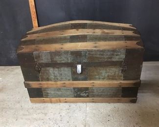 Hump back trunk. It is 29 inches wide, 17 inches front to back and 21 inches high. Strap handles missing on both ends. Both hinges are broken.