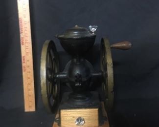 Coffee grinder/mill. This table top coffee mill has been restored. The cast iron part is absolutely correct but the base and drawer look like they have been replaced as has the knobs. The handle on the wheel looks original.